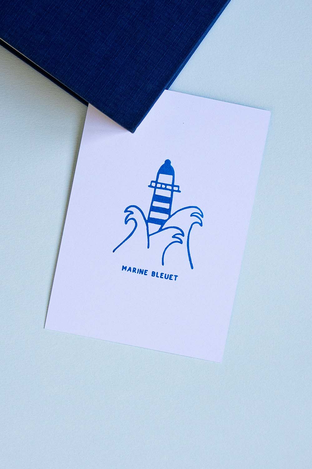 Portadilla de un libro estampada con un faro entre olas