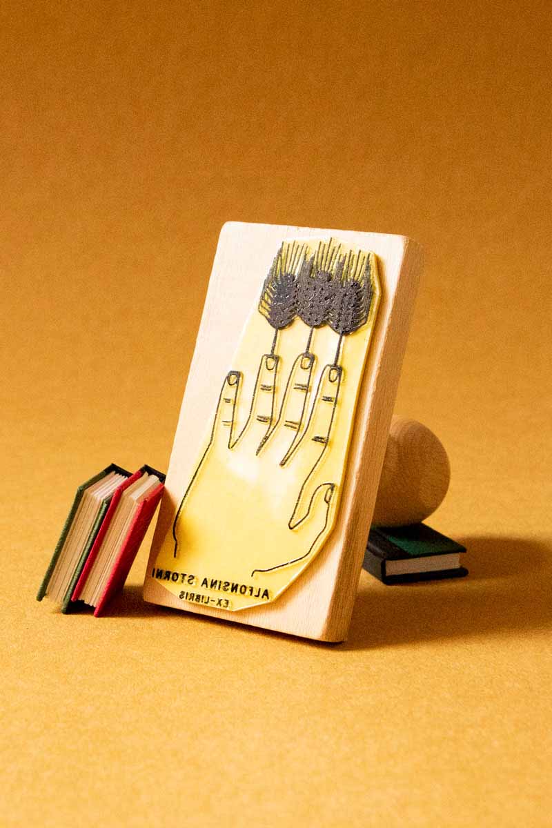 Sello ex-libris de una mano con tallos de trigo a modo de dedos