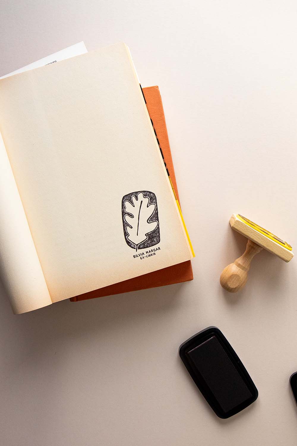 Portadilla de libro estampado con una hoja de roble y sello