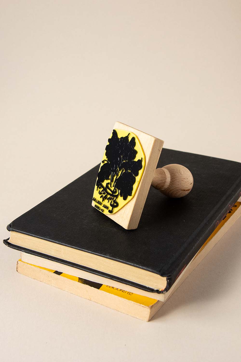 Sello ex-libris de una persona leyendo de una planta en una maceta con hojas anchas