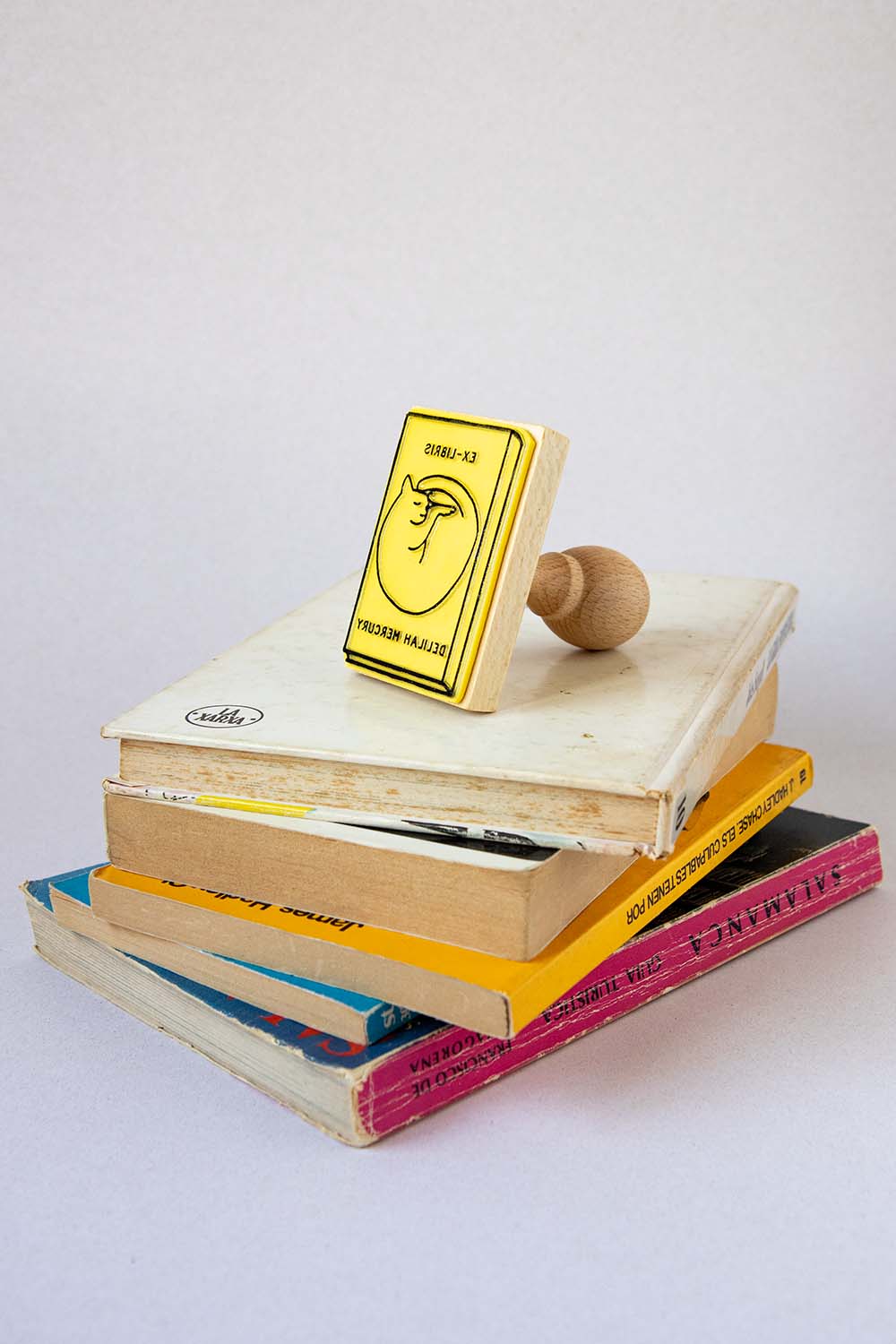 Sello exlibris grabado con un libro con en la portada un gato