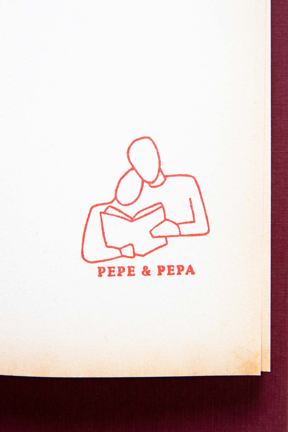 Portadilla de libro estampada con dos personas leyendo juntas un libro