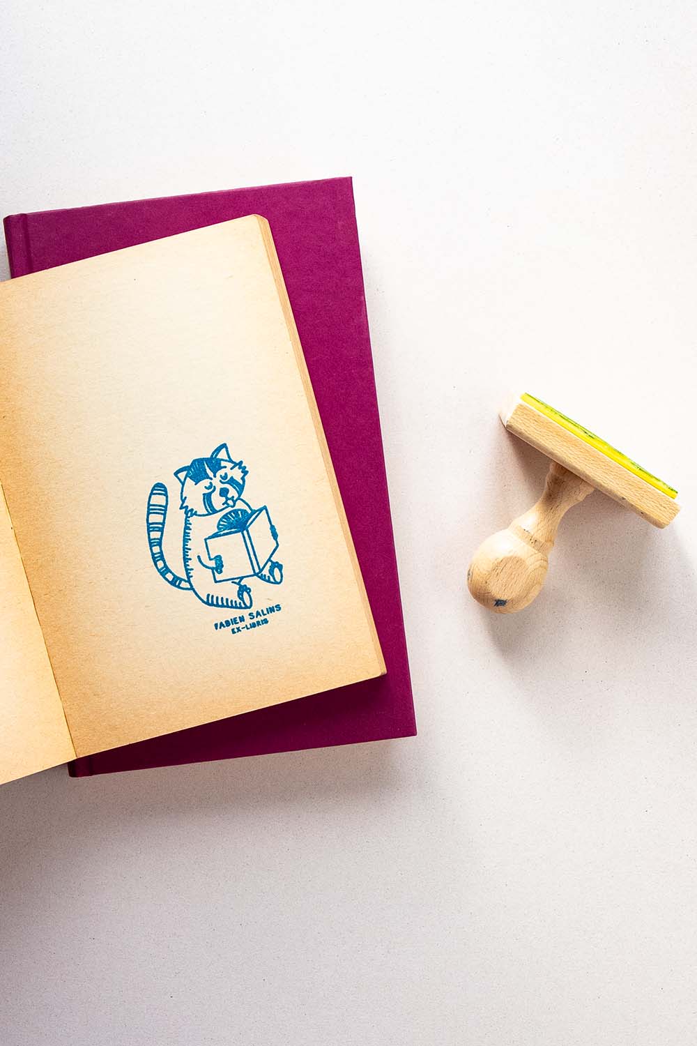 Portadilla de libro estampada con sello exlibris de un panda rojo leyendo y sello