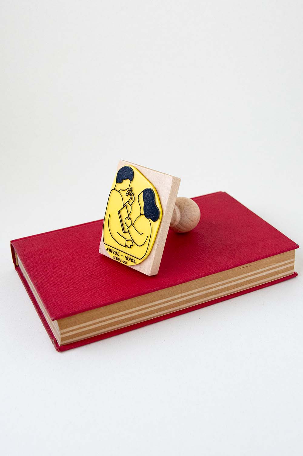 Sello exlibris grabado con una pareja leyendo y oliendo una rosa