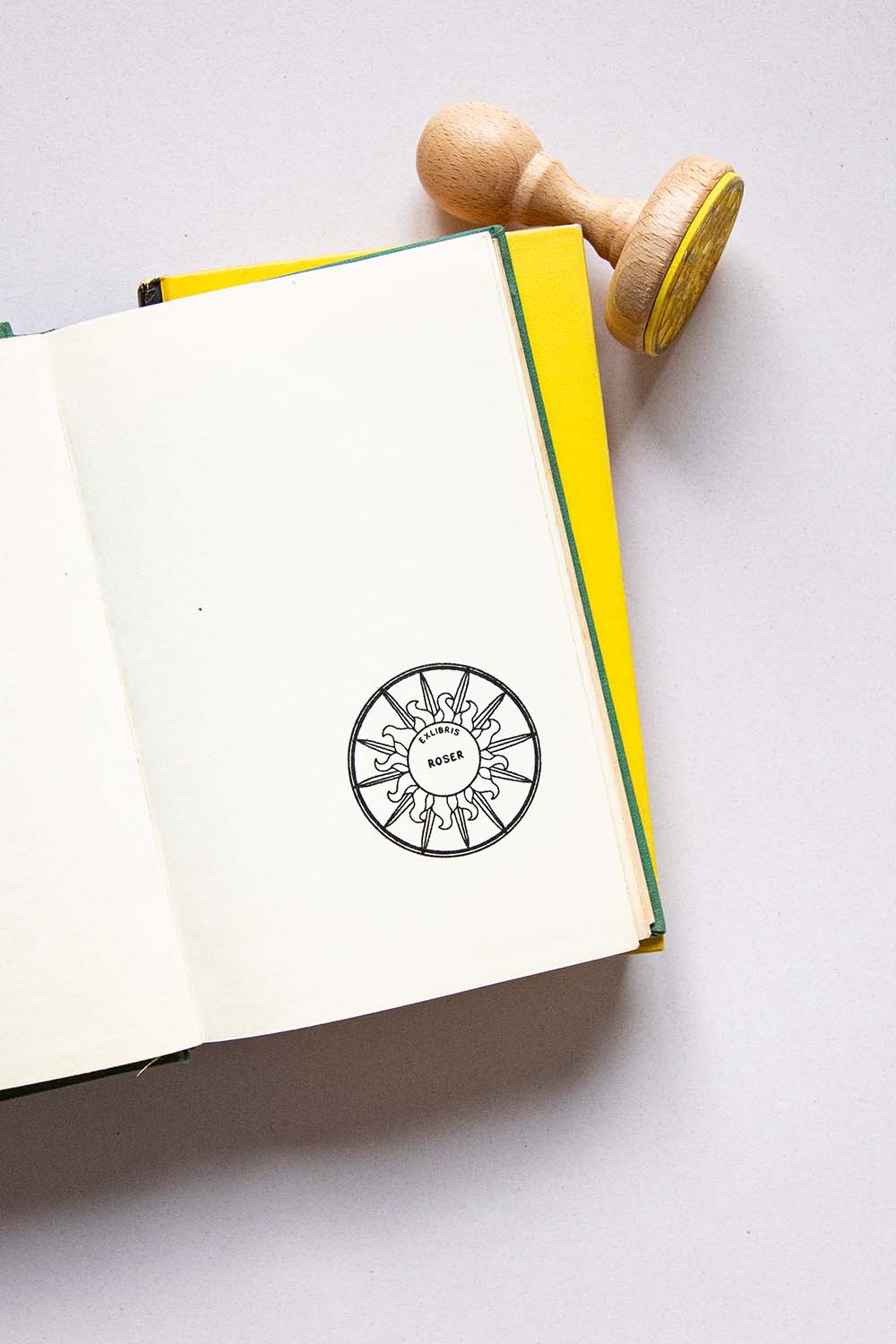 Portadilla de libro estampado con sello exlibris de un sol y sello