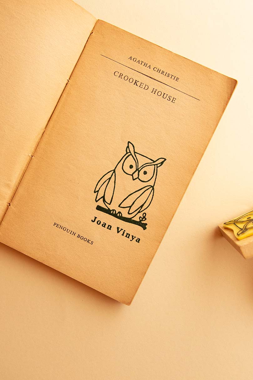 Portadilla de libro estampada con sello exlibris de un búho encima de una rama y sello