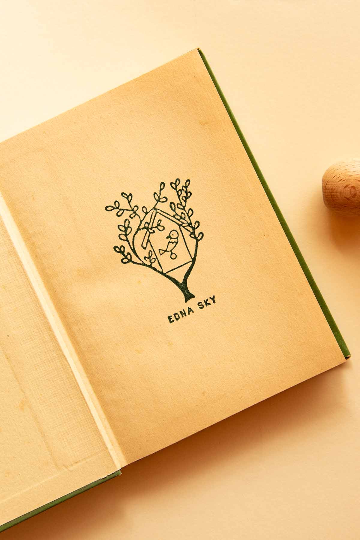 Portadilla de libro estampada con sello exlibris de una casita de pájaro y sello