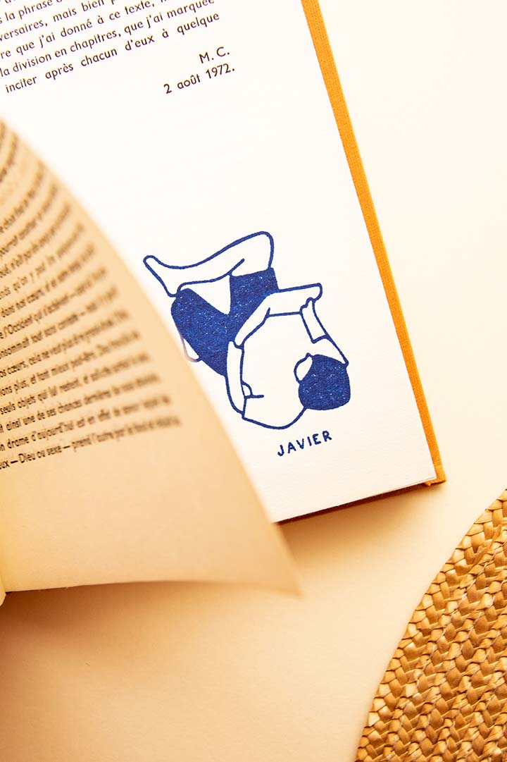 Página de libro estampada con un sello exlibris de una persona tumbada leyendo relajada con las rodillas