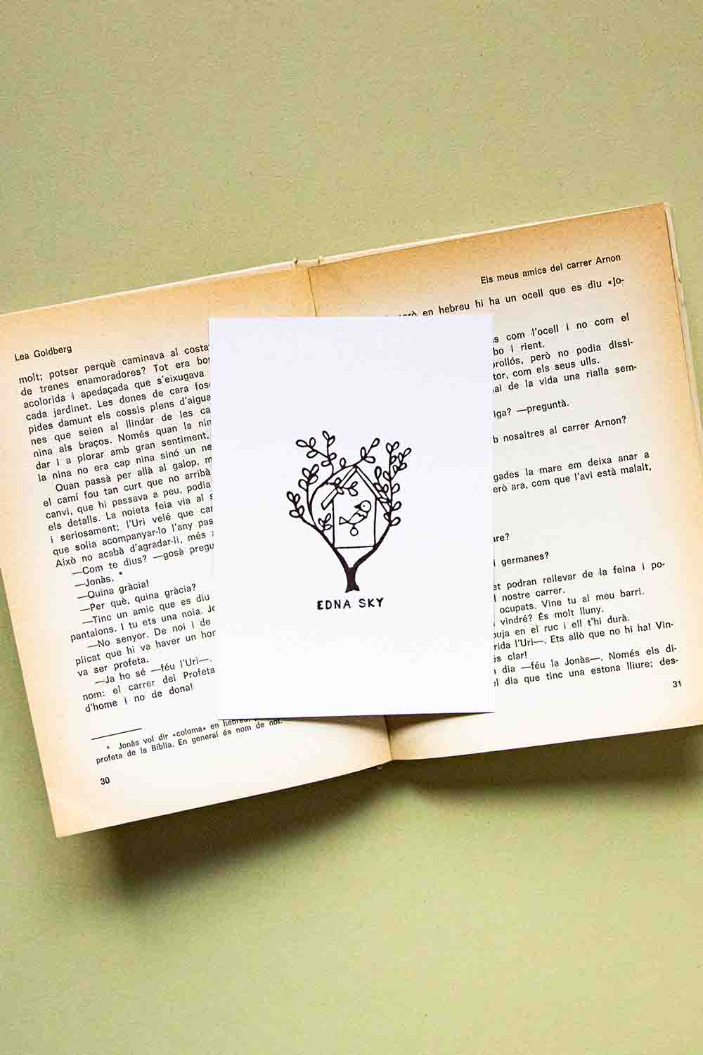 Portadilla de libro estampada con sello exlibris de una casita de pájaro