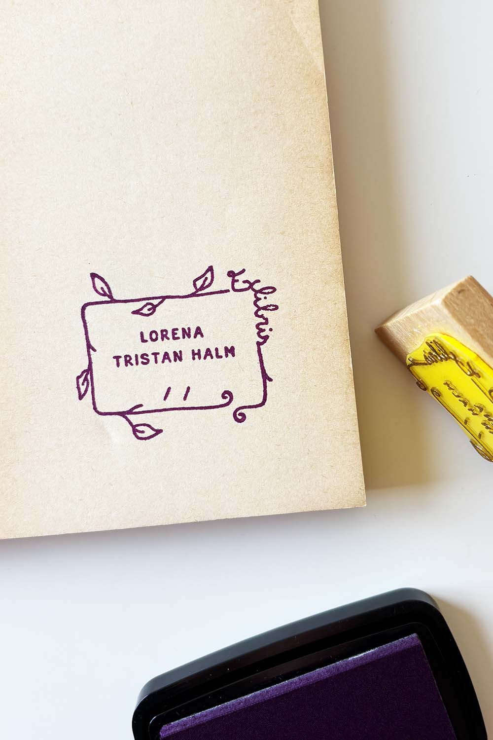 Portadilla de libro estampada con sello exlibris de forma rectangular con hojas y sello