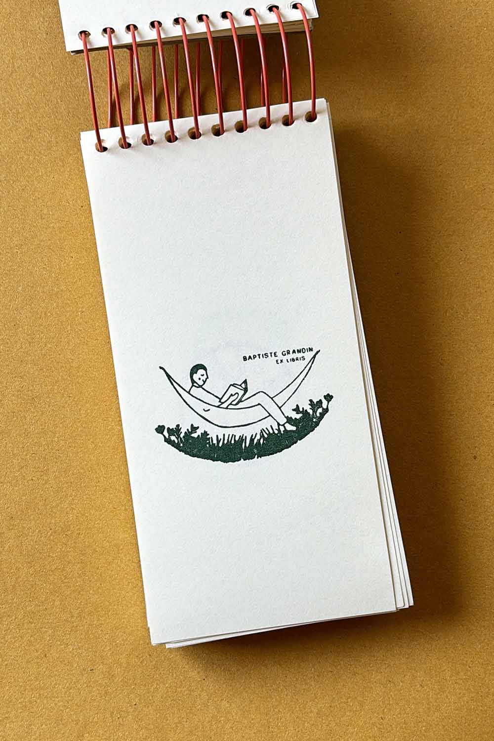 Portadilla de libro estampado con un hombre leyendo encima de una hamaca