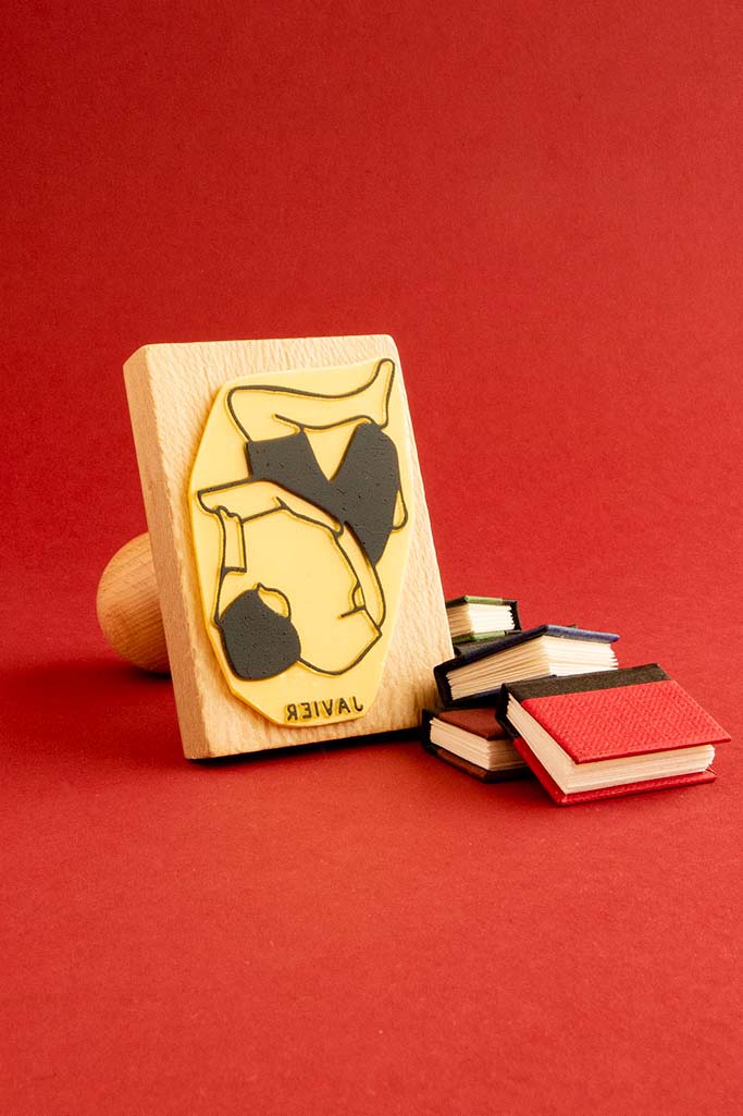 Sello exlibris grabado de una persona tumbada leyendo relajada con las rodillas