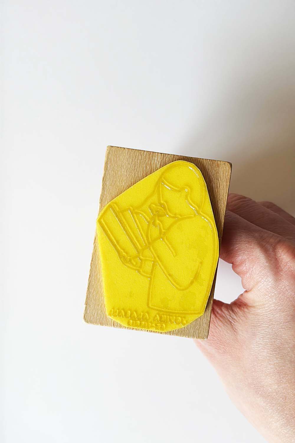 Sello exlibris grabado de una lectora leyendo y oliendo una rosa