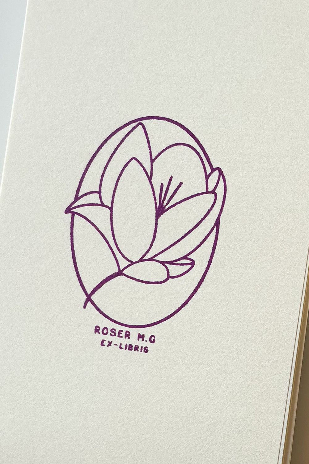 Portadilla de libro estampada con sello exlibris de una flor magnolia
