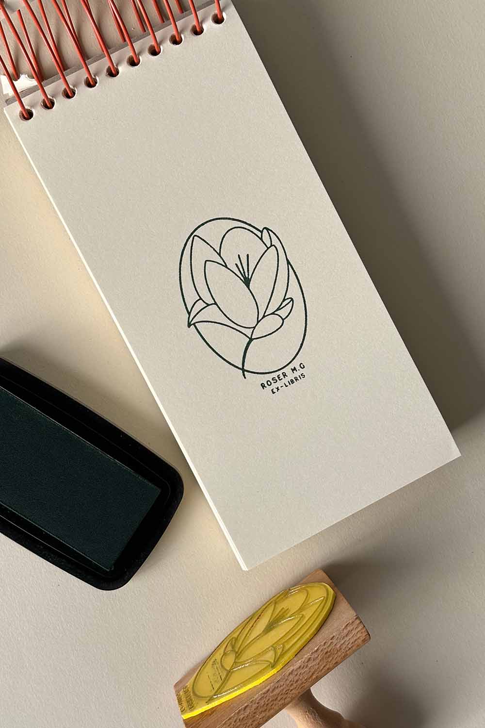 Portadilla de libro estampada con sello exlibris de una flor magnolia y sello