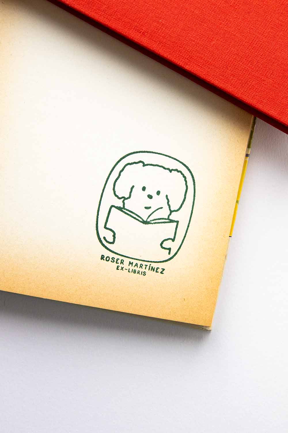 Portadilla de libro estampado con sello exlibris de un perro leyendo