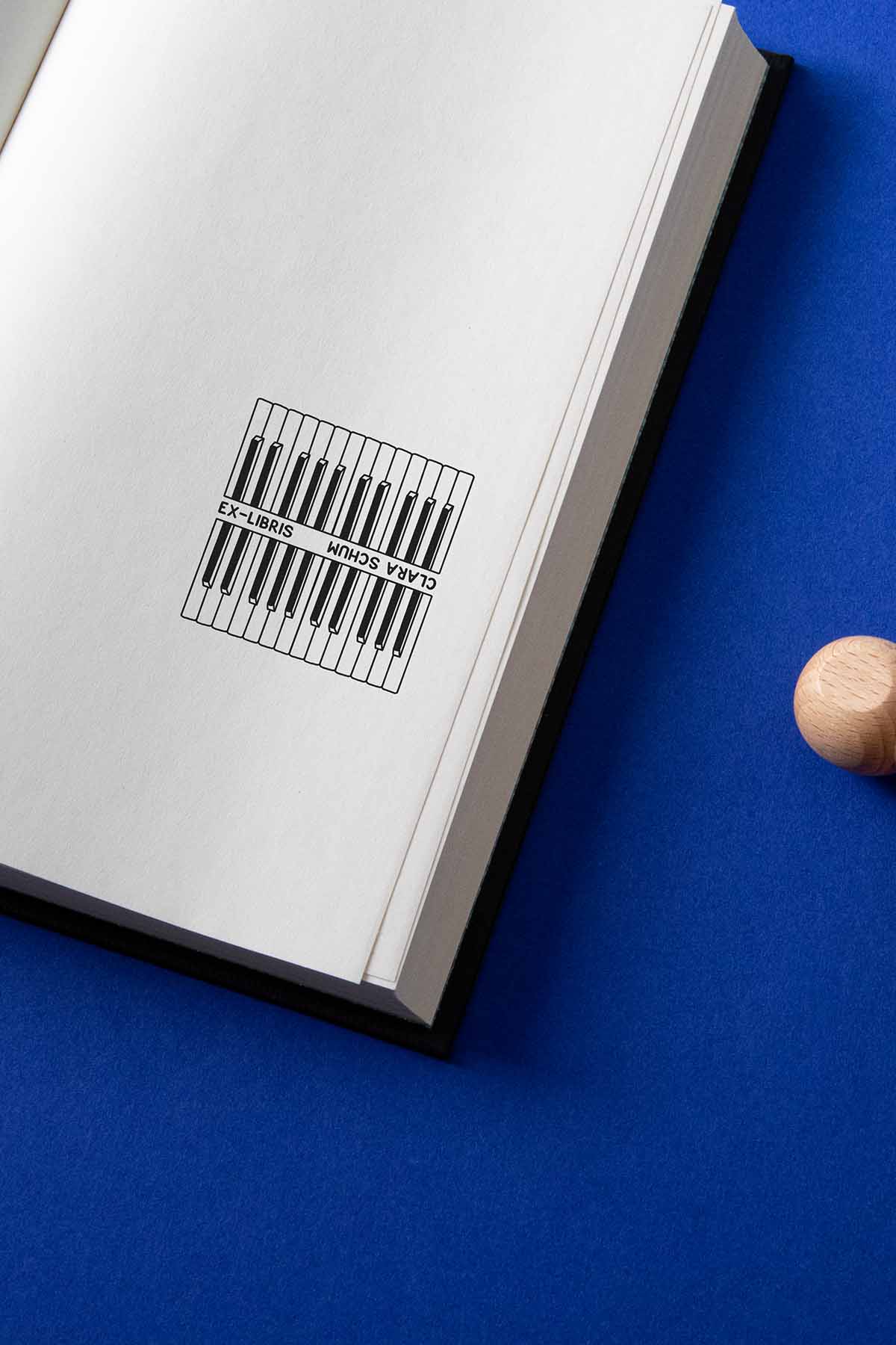 Portadilla de libro estampado con sello exlibris de dos teclados de piano