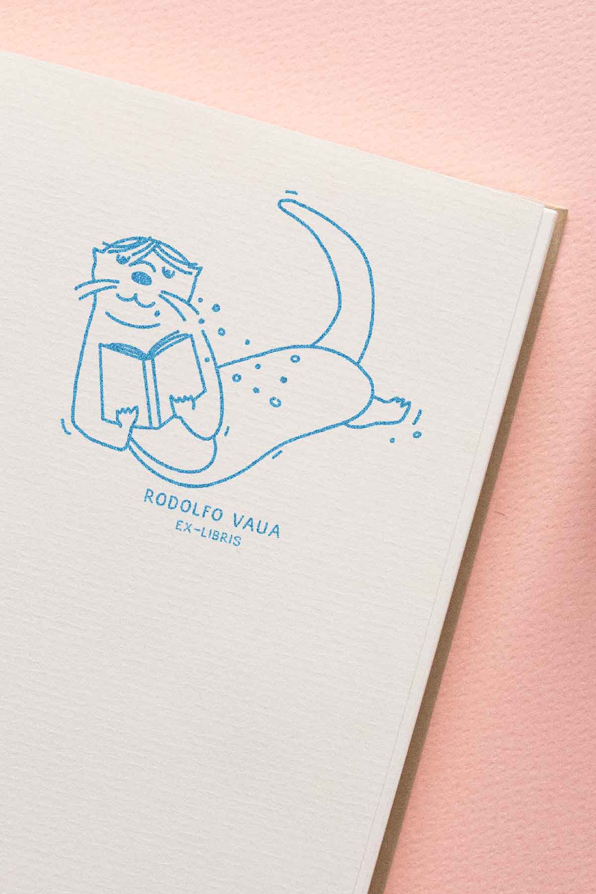 Portadilla de libro estampada con sello exlibris de una nutria letendo bajo el agua